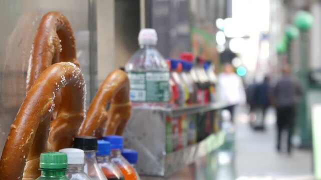 Pretzel for sale, street food in Manhattan, New York City, United States. Fast food counter, stall or kiosk, traditional pastry snack and soda drinks to go in NYC. Baked bread dessert, food on the go.