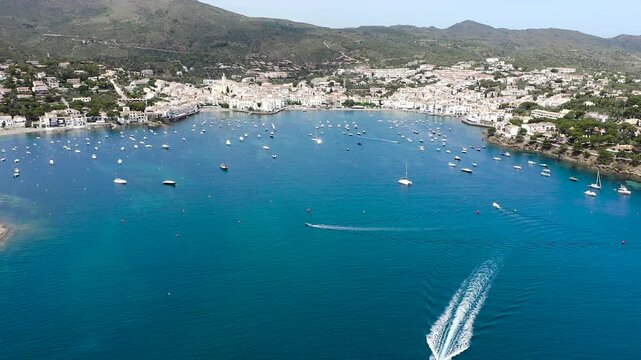 Aerial view of the picturesque fishing village of Cadaqu&eacute;s, featuring its whitewashed houses, historic waterfront, peaceful harbor and the crystal-clear waters of the Mediterranean on the Costa Brava.