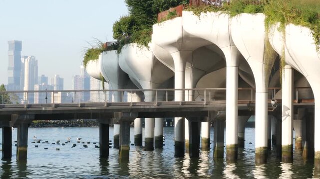 New York City Little Island pier park, oasis in Manhattan Midtown, United States. Urban architecture on pillars in Chelsea, USA. Futuristic contemporary concrete columns design, Hudson river landmark.