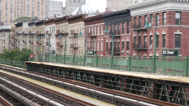 New York City Upper Manhattan subway outdoor station platform, 125 street sign, elevated metro in Harlem, United States railway. Residential district public metropolitan transport. Apartment houses.