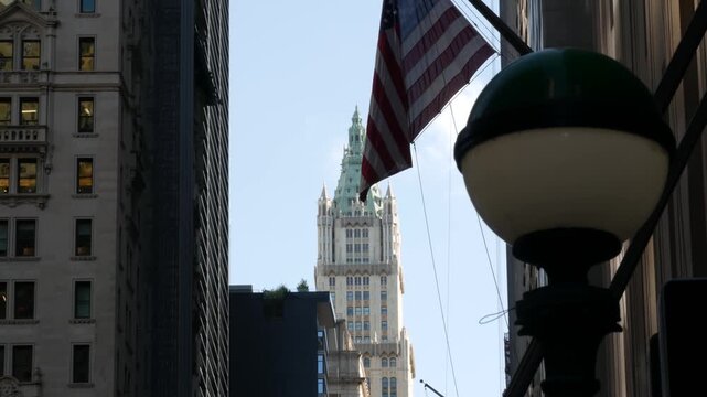 New York City Woolworth building 1913, skyscraper on Broadway in Downtown Financial District, Lower Manhattan, United States of America. Gothic historic architecture, cooper roof, USA american flag.