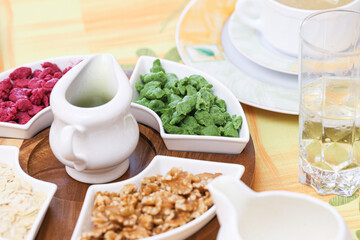 Fototapeta premium Colorful beetroot and spinach soup dumplings. Traditional soup garnish background for homemade cooking. Walnut and almond toppings enrich classic recipe. Rustic table serving looks fresh.