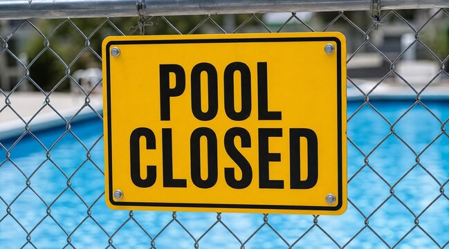 Pool closed sign on chain link fence