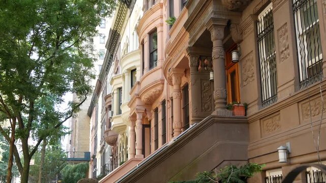 New York City townhouse buildings, brownstone row houses in Manhattan or Brooklyn, United States of America. Classic buildings on residential district street. Real estate property. Rowhouse townhome.