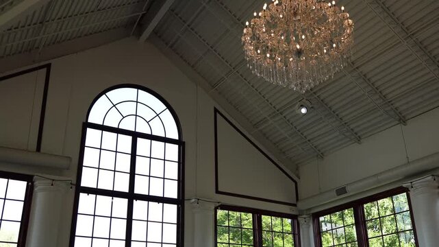Bright hall interior with chandelier and arched window