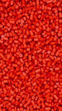 Pan across red polypropylene plastic granules and industrial masterbatch resin pellets, 3D render dynamic Vertical video.