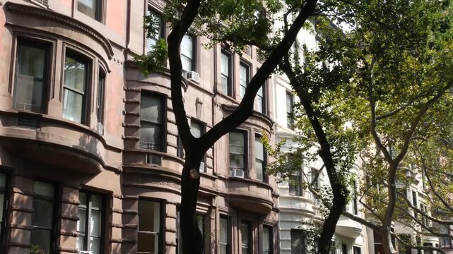 New York City townhouse buildings, brownstone row houses in Manhattan or Brooklyn, United States of America. Classic buildings on residential district street. Real estate property. Rowhouse townhome.