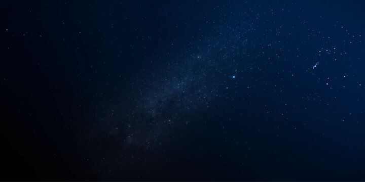 The Milky Way galaxy is seen from Earth, a celestial spectacle of shimmering stars and cosmic dust painting the deep blue night sky with ethereal beauty and awe-inspiring wonder.