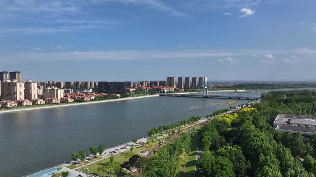 Rizhao city riverside landscape with modern buildings and green parks under clear blue sky