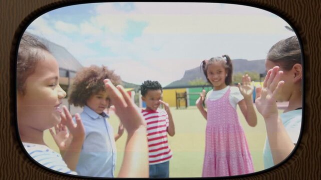 Five kids standing on school turf, girl in pink raising hands playing high-fives, vignette framing