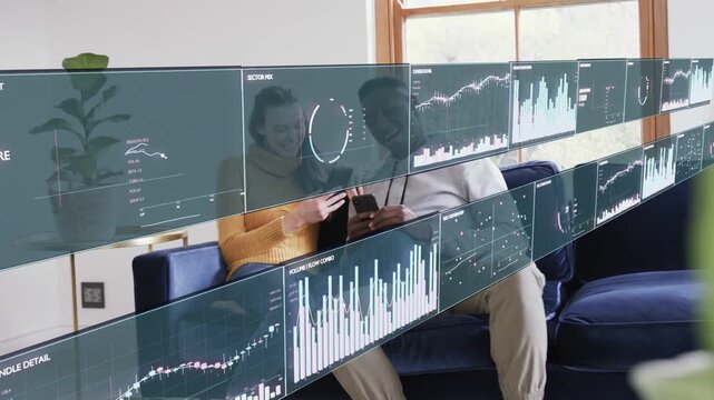 Couple on couch tapping smartphone holo finance panels sliding and updating charts checking data