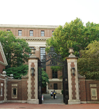 Cambridge, MA - USA - 08-03-2025: People walk through the gates into the campus of Harvard University in Cambridge, Massachusetts