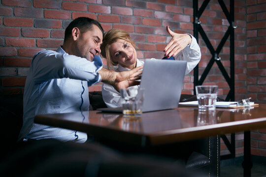Happy business people working together on laptop in a restaurant