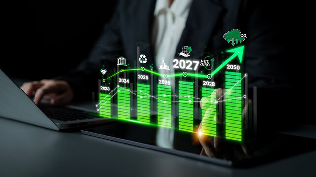 Business professional analyzing growth chart with sustainability icons and future projections for 2027 and 2050, demonstrating environmental commitment Sigmoid