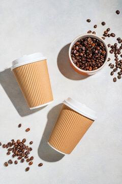 Roasted Coffee Beans and Takeaway Coffee Cups with on Light Background
