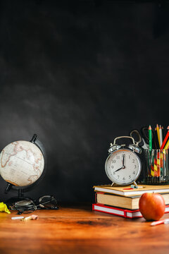 Classroom essentials with coloured pencils and alarm clock, learning concept