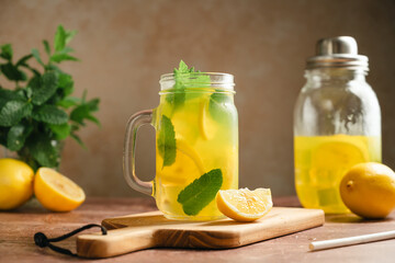 Fototapeta premium Homemade iced lemonade drink, with fresh mint leaves served in mason jar mug, rustic summer cold drink concept, rustic still life
