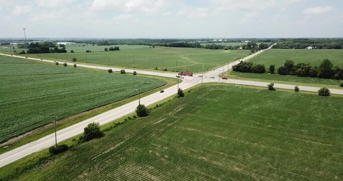 Aerial drone video of a busy intersection in the middle of agricultural farmland in rural America.