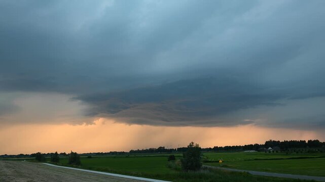 Time-lapse of slight anti cyclonic rotation in the base of a strong thunderstorm over province of Flevoland, Netherlands at sunset.