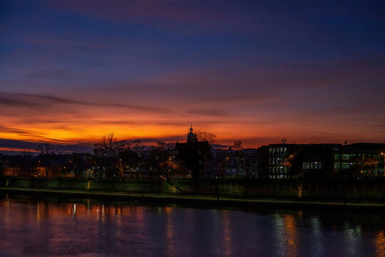 Black silhouettes of houses and churches against sunset sky. Sunset over Vistula river in Krakow, Poland