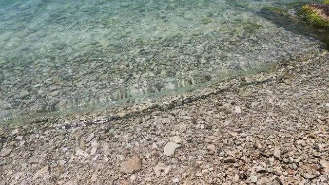 Waves on pebbles beach at Garda Lake, Bardolino, Italy
