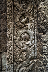 Ancient stone relief carving depicting an animal resembling a stegosaurus on a temple wall at Ta Prohm Siem Reap Cambodia © Chris Jones