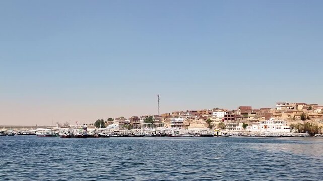 Numerous traditional motorboats for tourist transport moored at the marina near the philae temple complex, navigating the calm nile waters