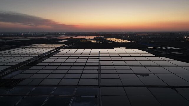 Sunset over salt fields in Rizhao with reflective water surfaces and geometric patterns