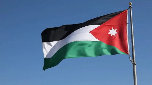 The national flag of the hashemite kingdom of jordan waving against a clear blue sky