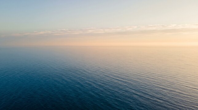 Wide ocean horizon with light cloud cover