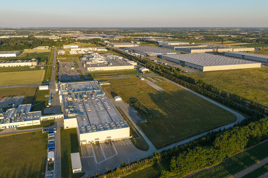Aerial view of a modern industrial facility for carbon neutral food production with large warehouses, loading docks, and surrounding green fields in Piorunow, Masovian Voivodeship, Poland.