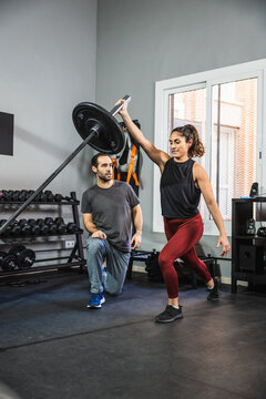 Woman doing landmine lunge press with trainer