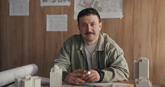 Man at desk with architectural models and plans in office