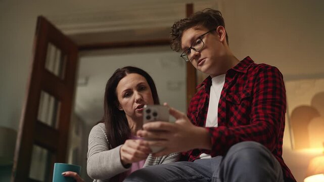 Teen boy explaining to his mother how to use a new app, showing AI assistant