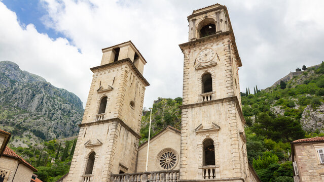 Wide architectural view of Cathedral of Saint Tryphon in Kotor, Montenegro with dramatic mountain backdrop