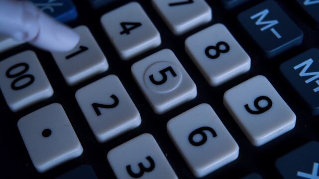 Humanoid robotic hand typing on an office calculator in first-person view. AI in modern life.Close-up shot of automated accounting and fintech technology.
