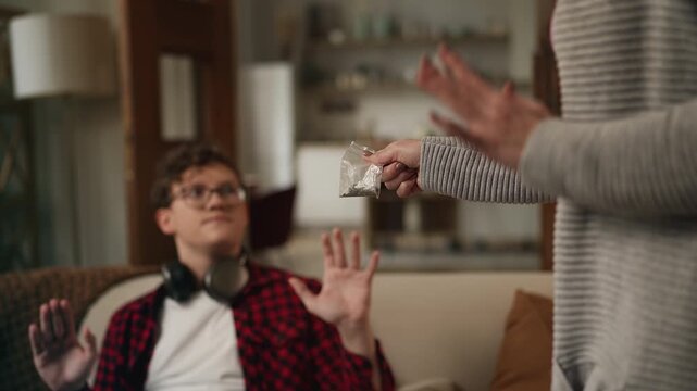 Mother reprimanding her adolescent son for smoking marijuana, unhealthy habits