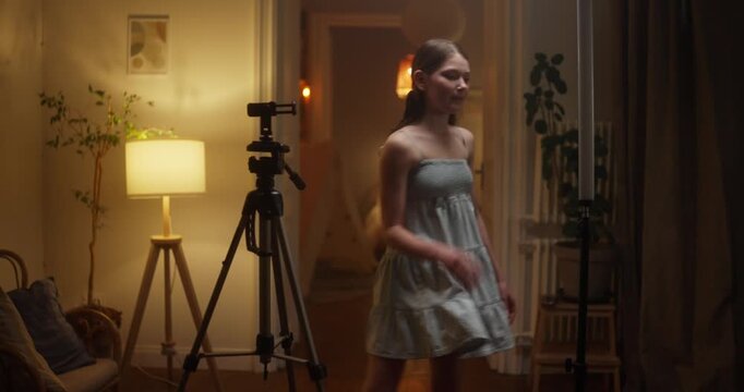 Woman filming herself on a tripod at home