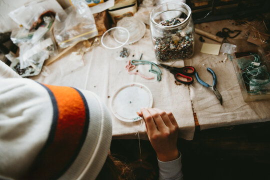 Child making beaded jewelry