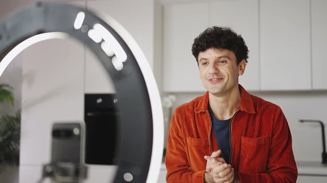 Friendly young man recording social media video on phone, lifestyle blogging