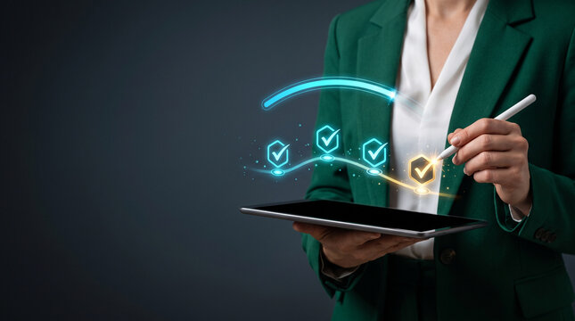Businesswoman using stylus on digital tablet with futuristic quality assurance checkmark icons milestone dashboard for project completion and compliance tracking