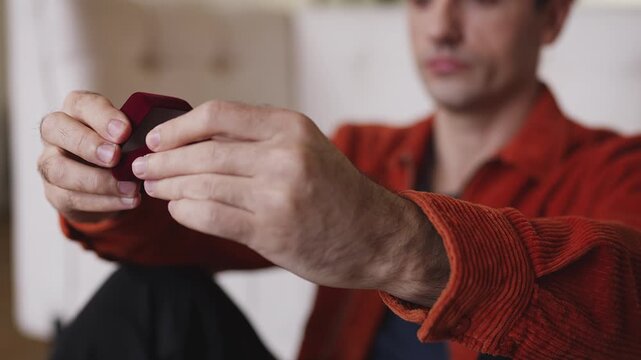 Sad young man holding engagement ring, upset after proposal rejection