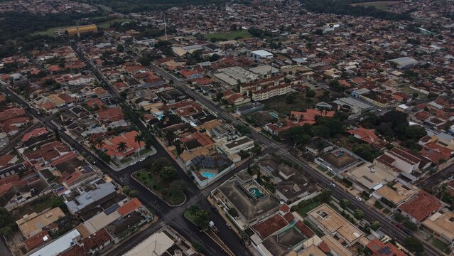 Aerial view of a suburban neighborhood with red tiled roofs and tree lined streets
