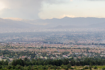 Fototapeta premium Panoramic misty view of Cochabamba city valley from Pairumani hills in Bolivia
