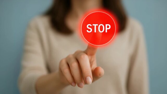Person pressing a glowing red "Stop" button hologram with fingertip, touchscreen interaction and shallow depth of field