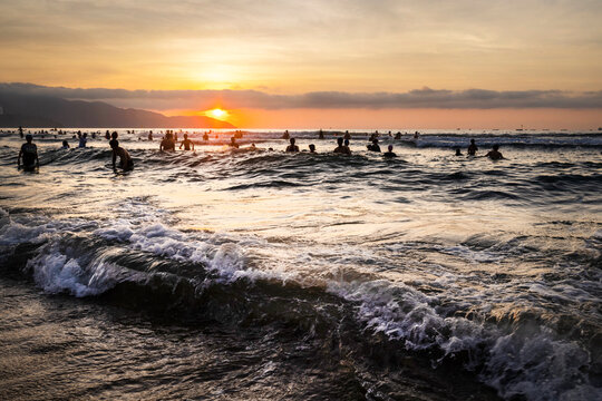 People relax and bathe,on Da Nang Beach at sunset,along the central coast of Vietnam.