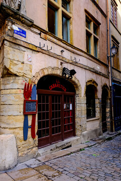 Lyon, France - 10.03.2026. A street-level view of the historic stone storefront of "Le Cabaretier," a traditional bouchon restaurant located on the corner of Rue de la Fronde in the Vieux Lyon distric