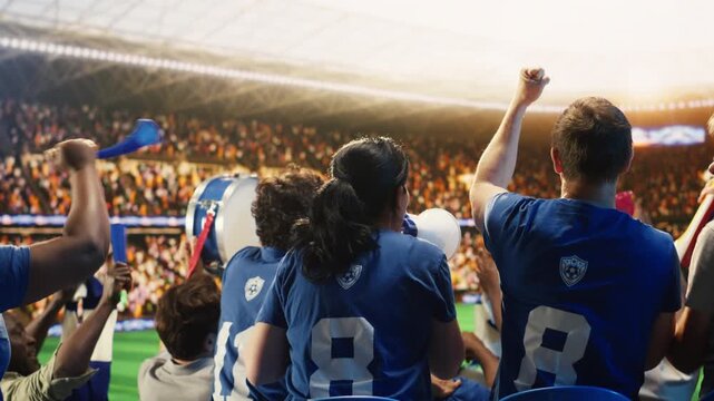 Cheerful football supporters waving scarves in stadium stands during emotional match celebration, showing ecstatic fans in sports arena jumping up and down after winning soccer competition.