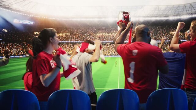Football supporters in red jerseys blow vuvuzelas and create lively stadium atmosphere for fan culture, stadium atmosphere and team support content.
