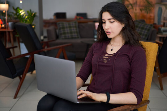 Happy successful businesswoman working on laptop in co-working place, smiling female entrepreneur using laptop in cafe